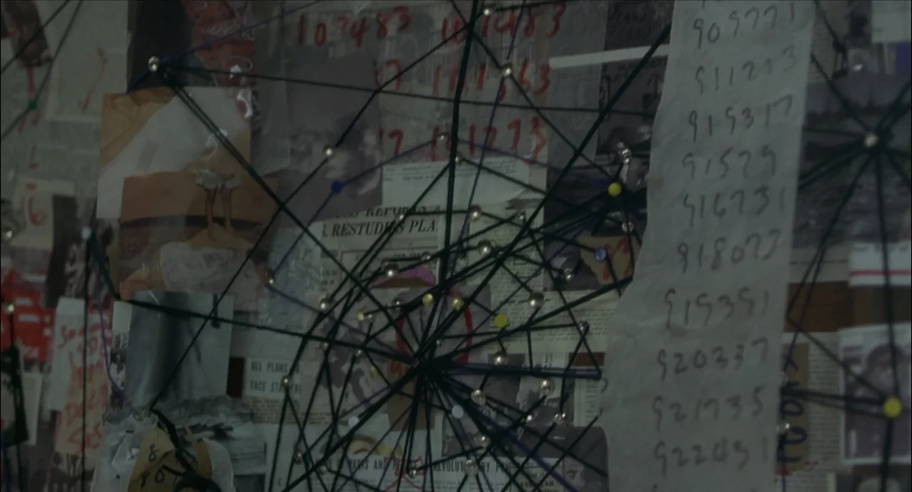 Newspaper clippings and handwritten notes connected by strings in A Beautiful Mind (2001).